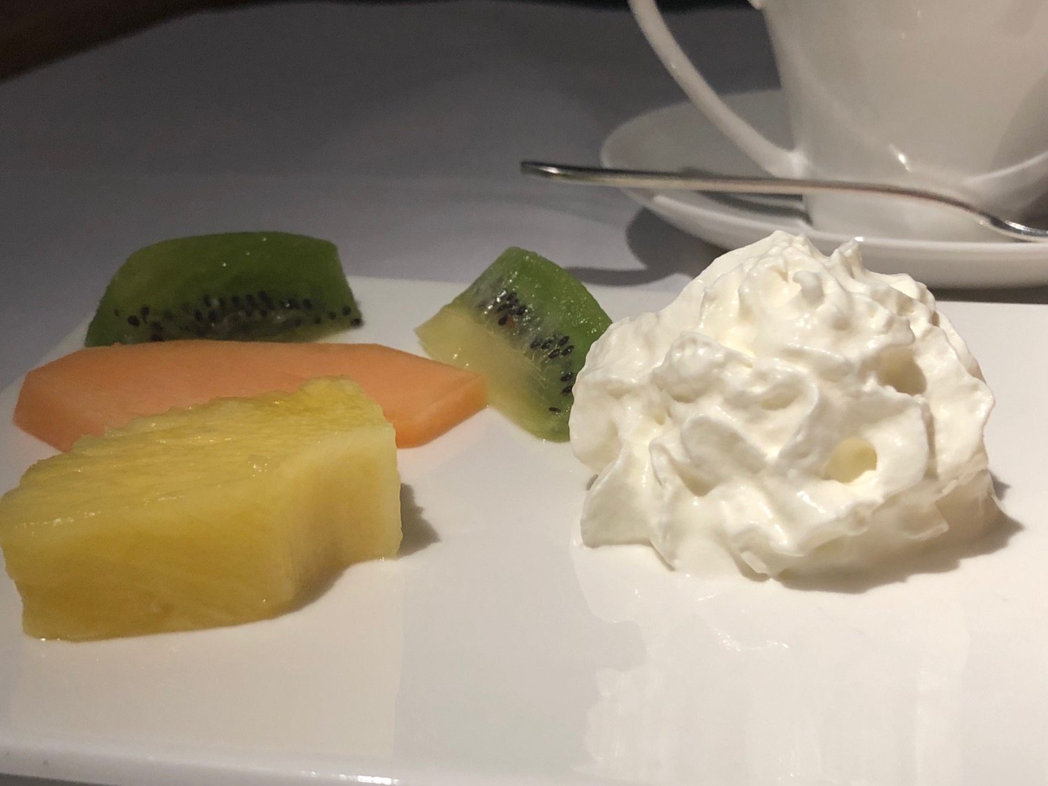 a plate of fruit and whipped cream