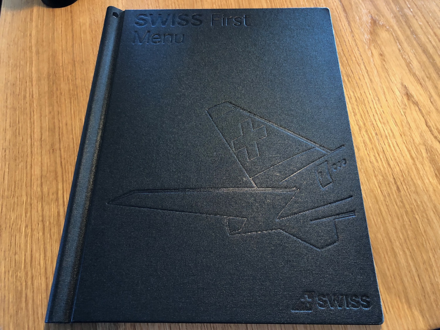 a black menu cover on a wood surface