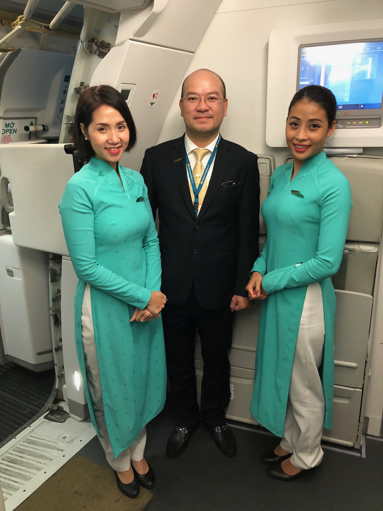 a man and two women standing in a plane