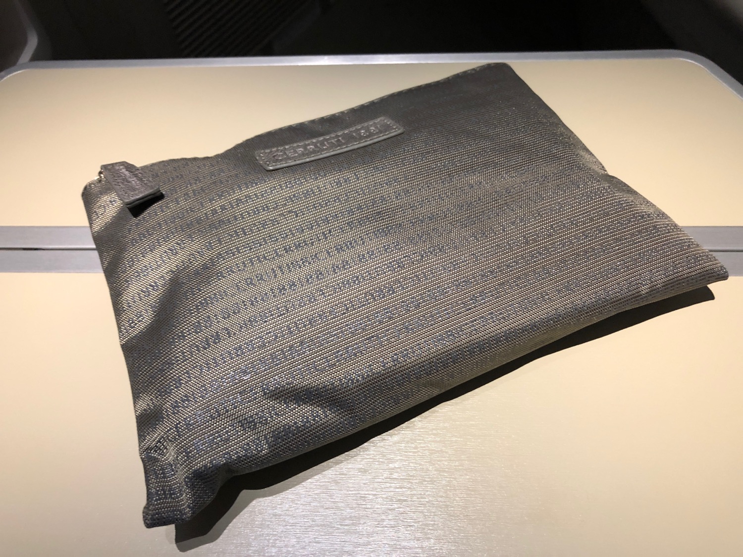 a grey bag on a white surface