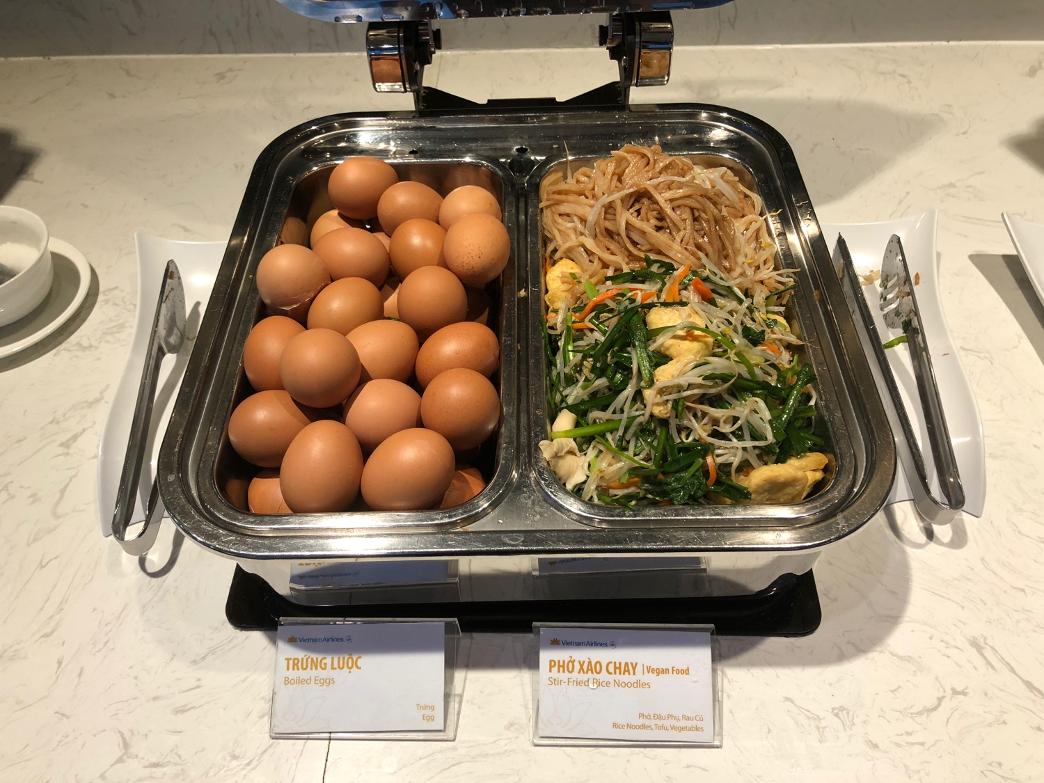 a tray of food with eggs and noodles
