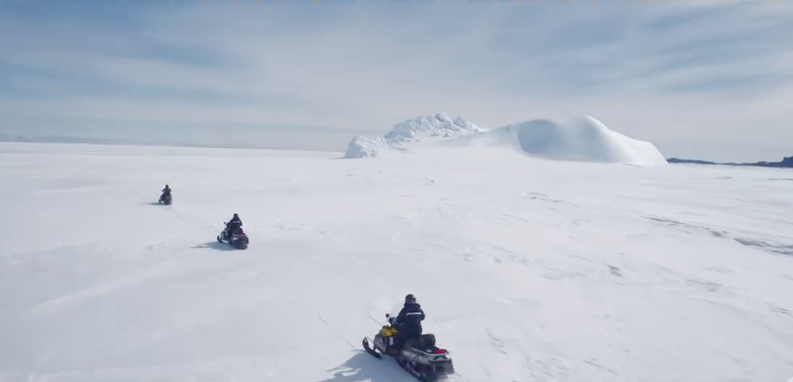 a group of people on snowmobiles in the snow