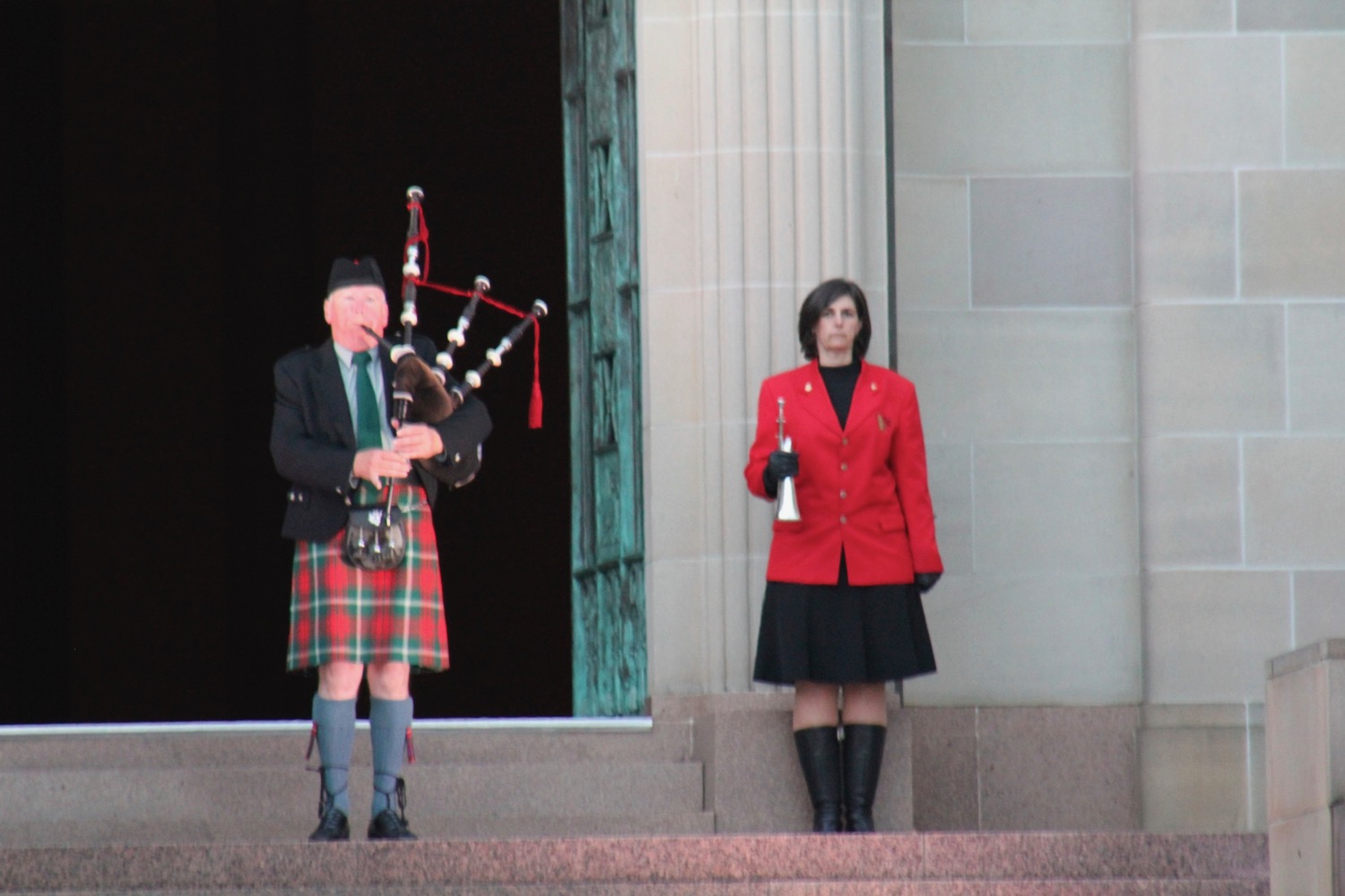 a man playing bagpipes next to a woman