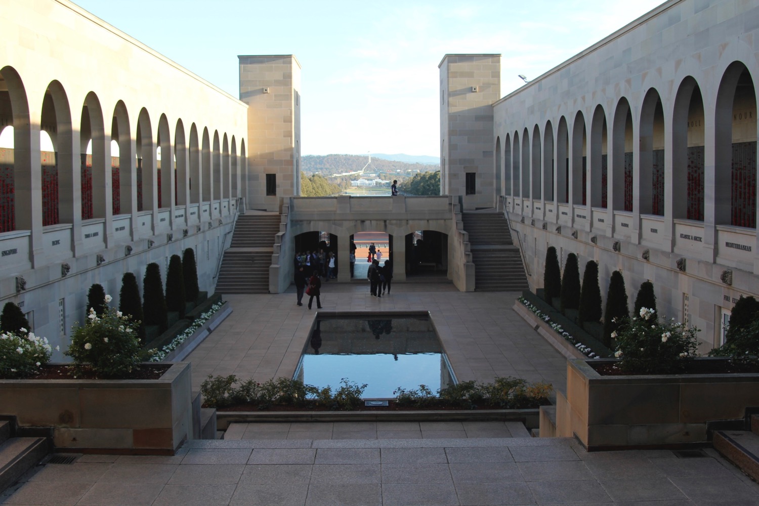 a courtyard with arches and a pool of water