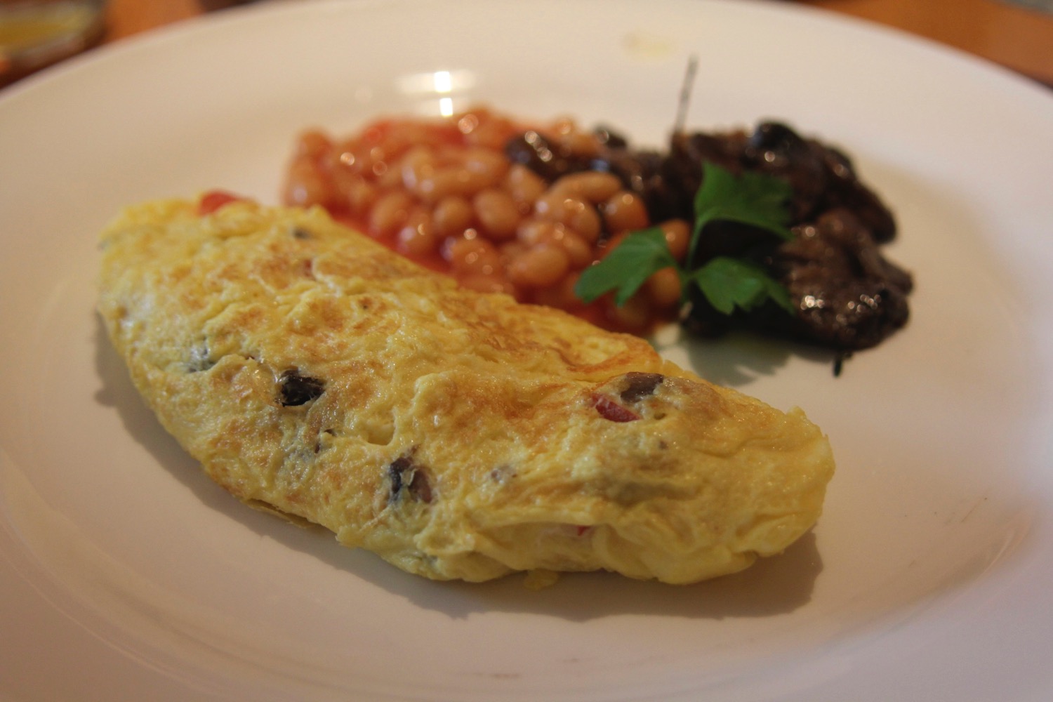 a plate of food with beans and omelette