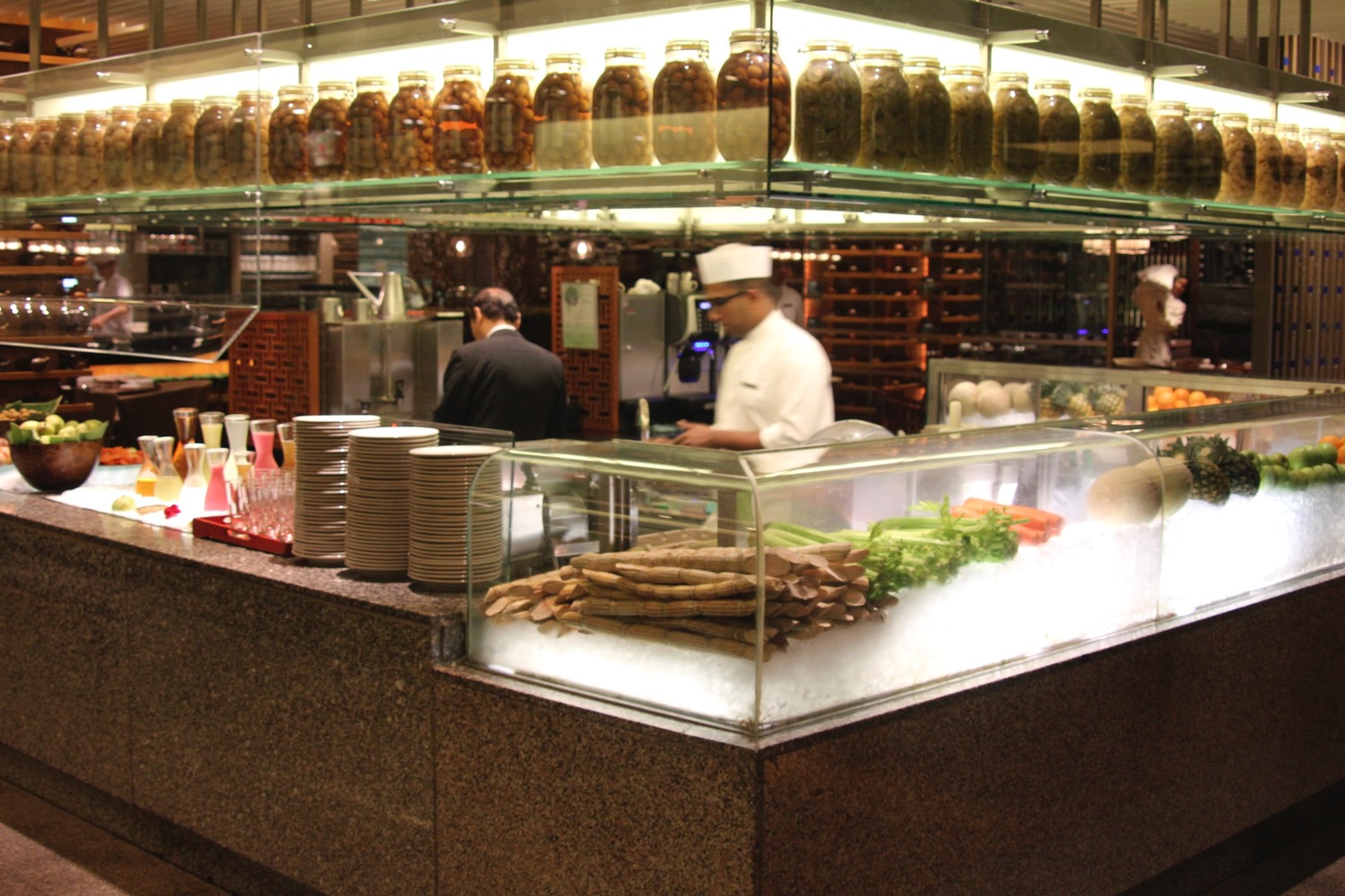 a chef behind a counter with food