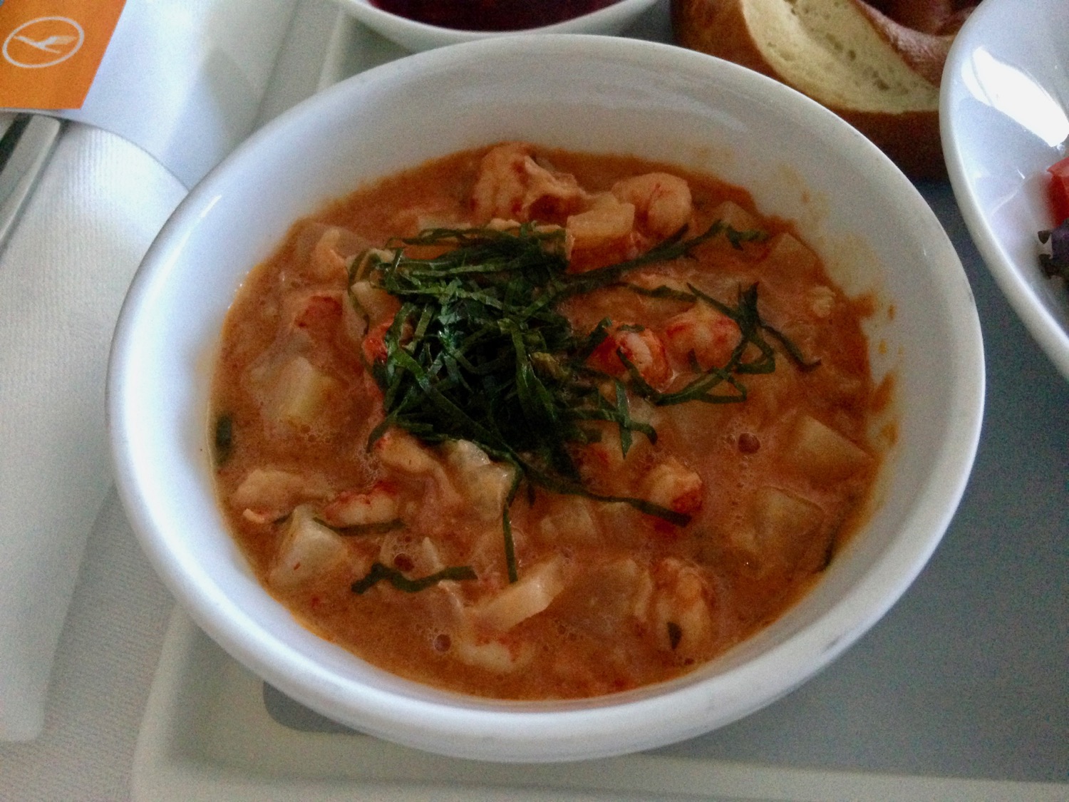 a bowl of soup with shrimp and vegetables