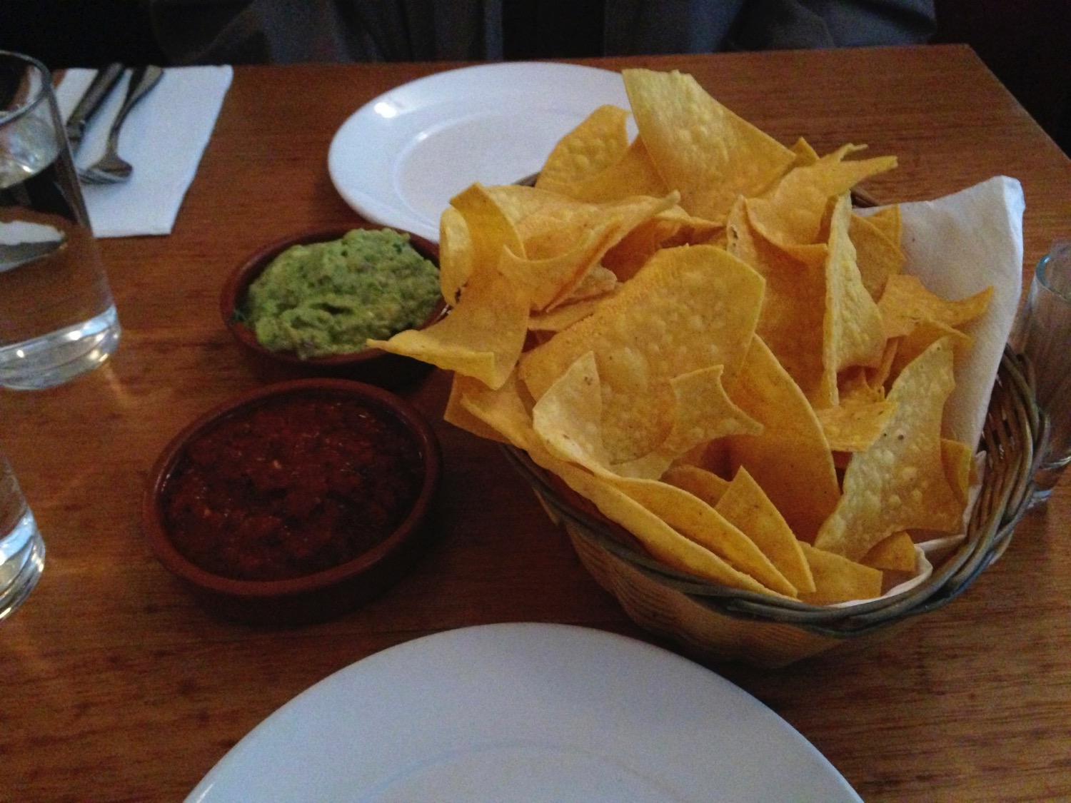 a basket of chips and dips on a table