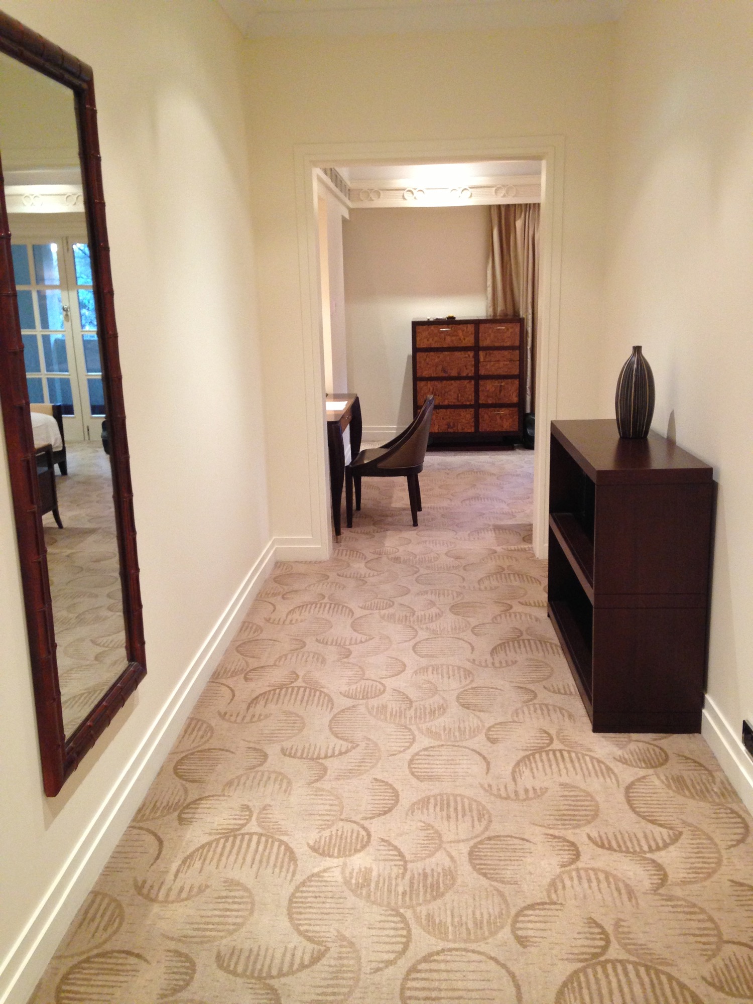 a hallway with a mirror and a dresser