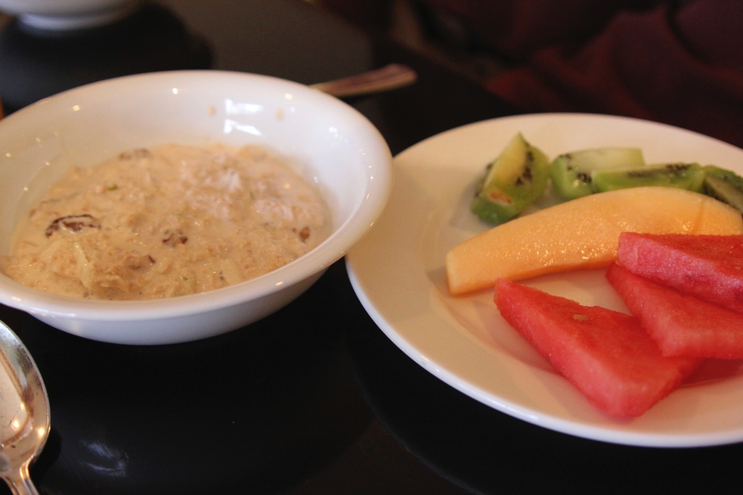 a bowl of oatmeal and fruit on a plate