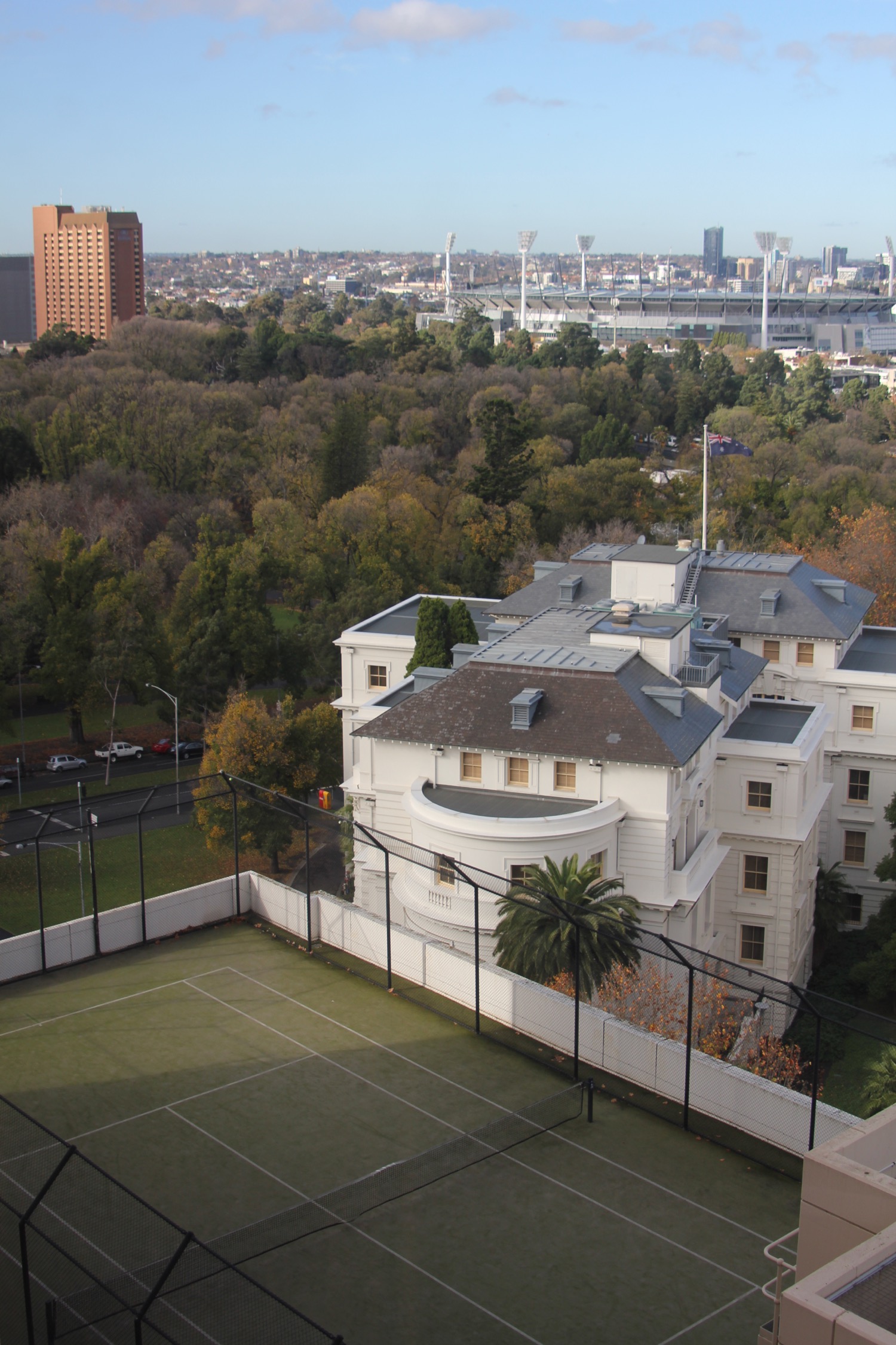 a tennis court with a large building in the background