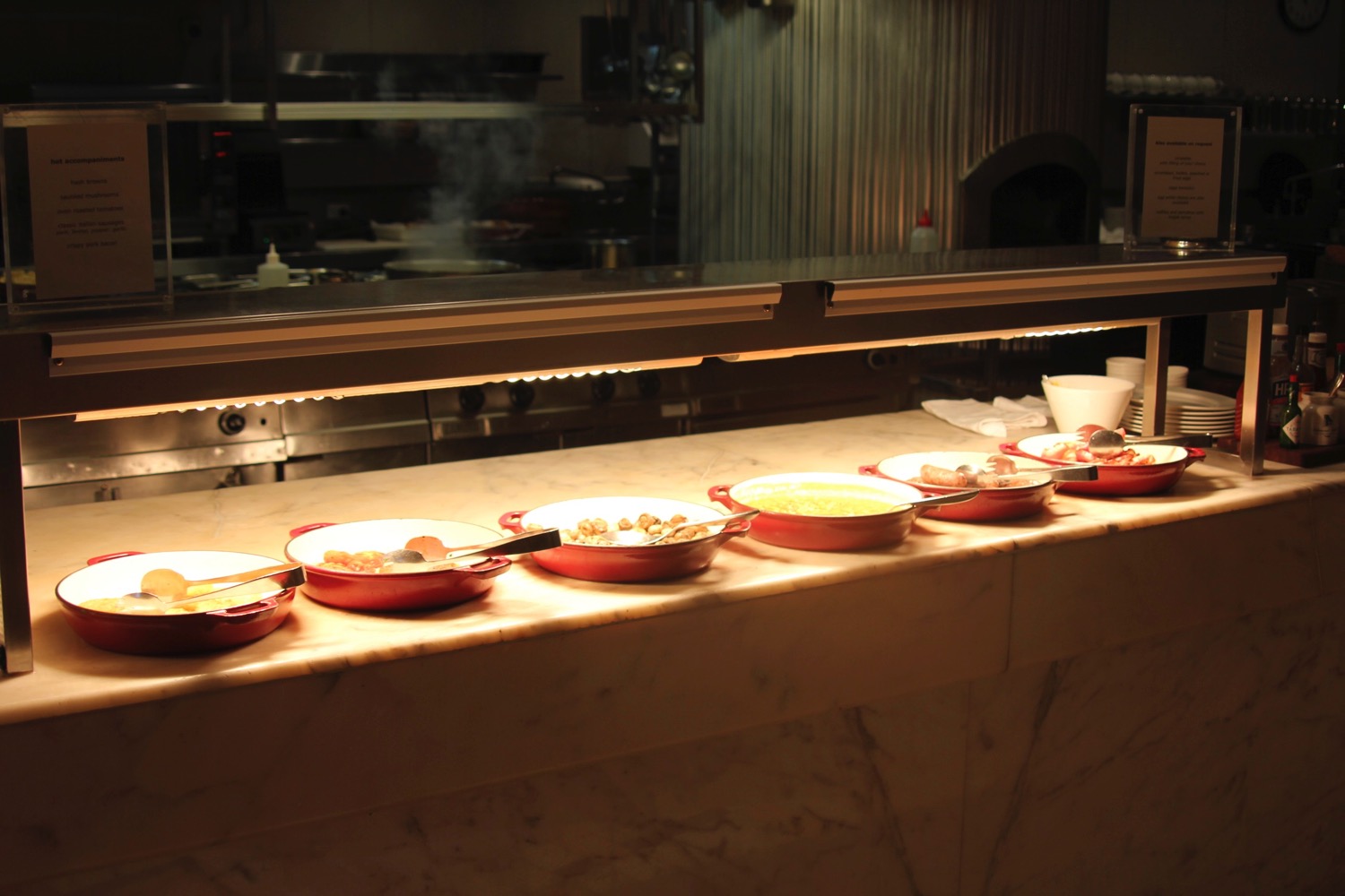 a row of bowls of food on a counter