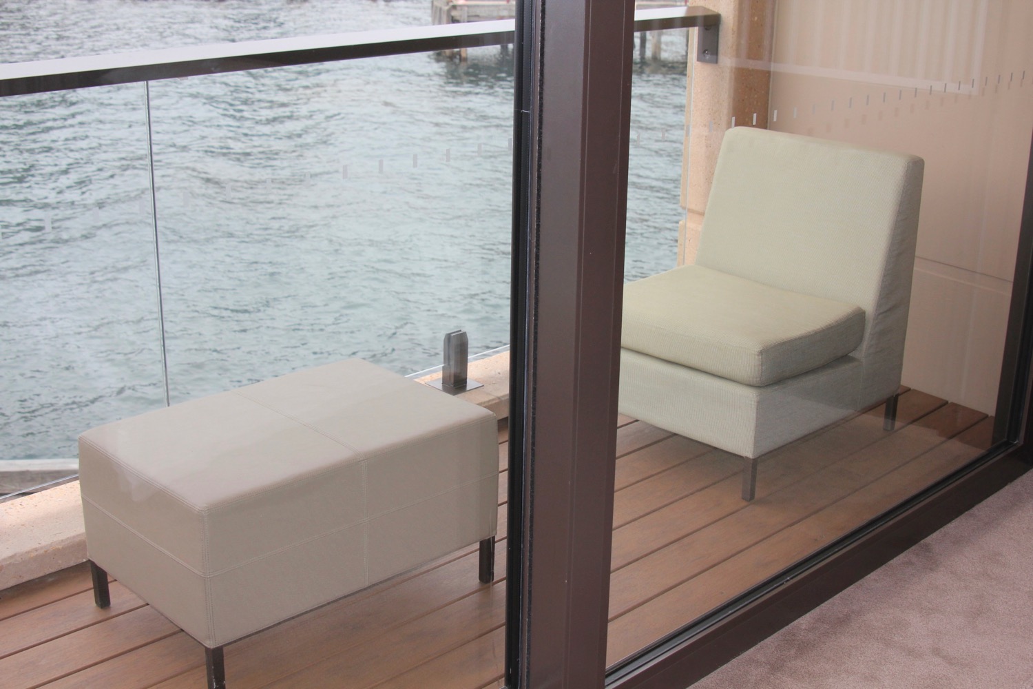 a chair and ottoman outside of a glass door