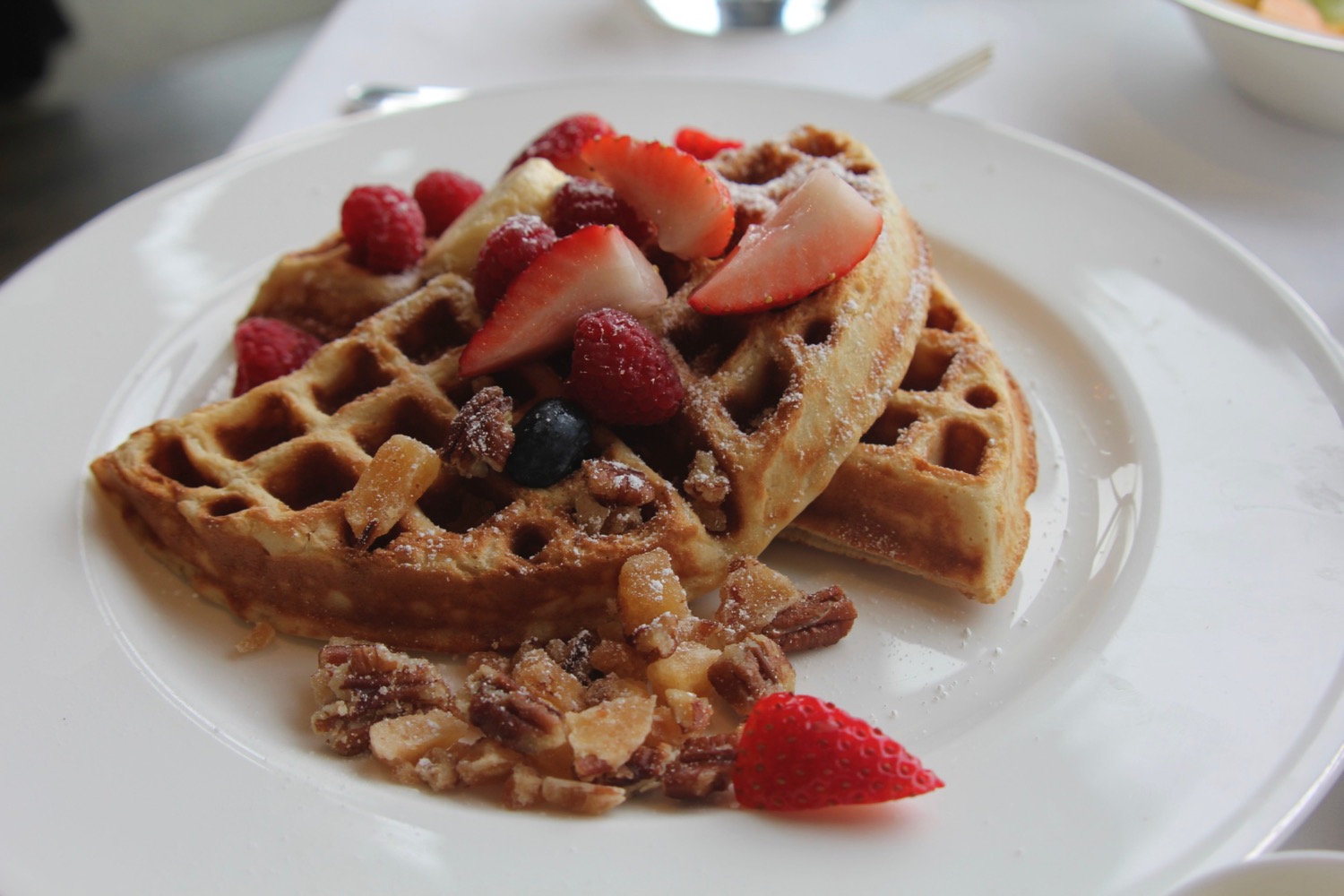 a plate of waffles with fruit on it