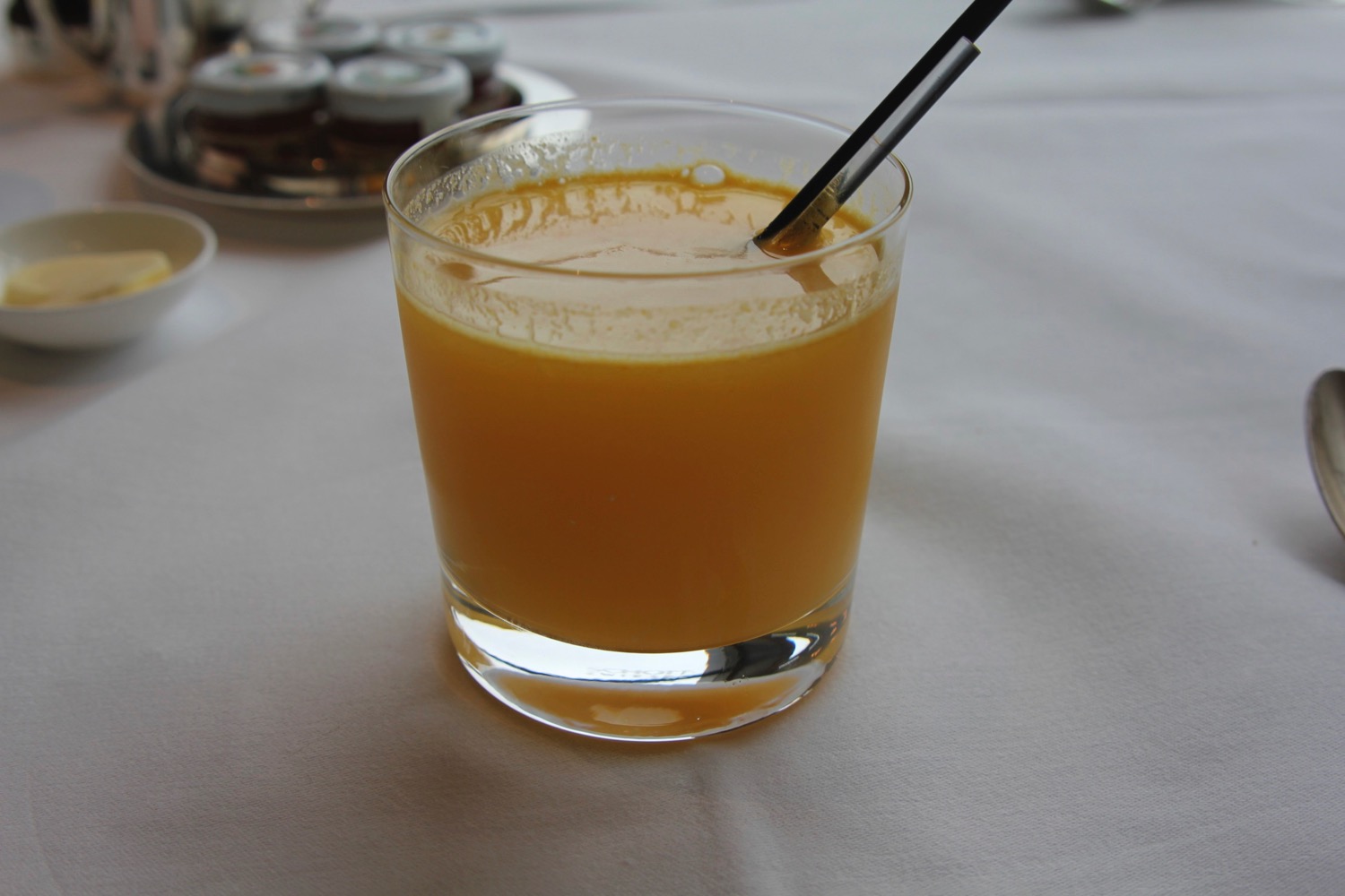 a glass of orange juice with a straw