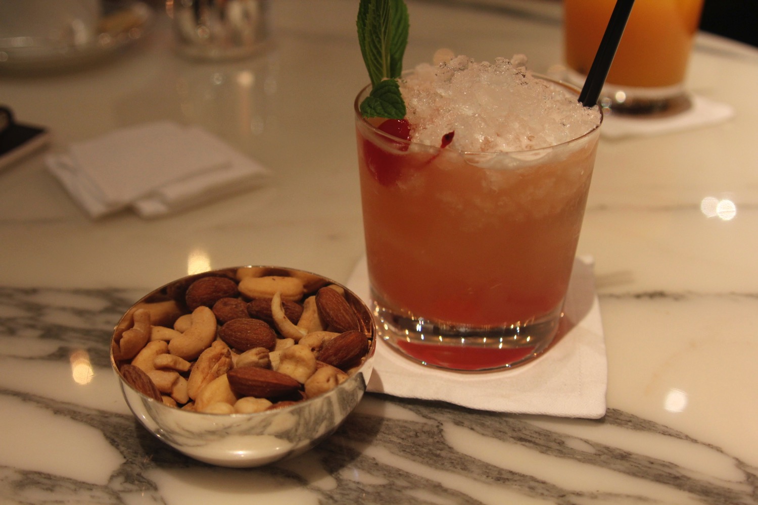 a drink and a bowl of nuts