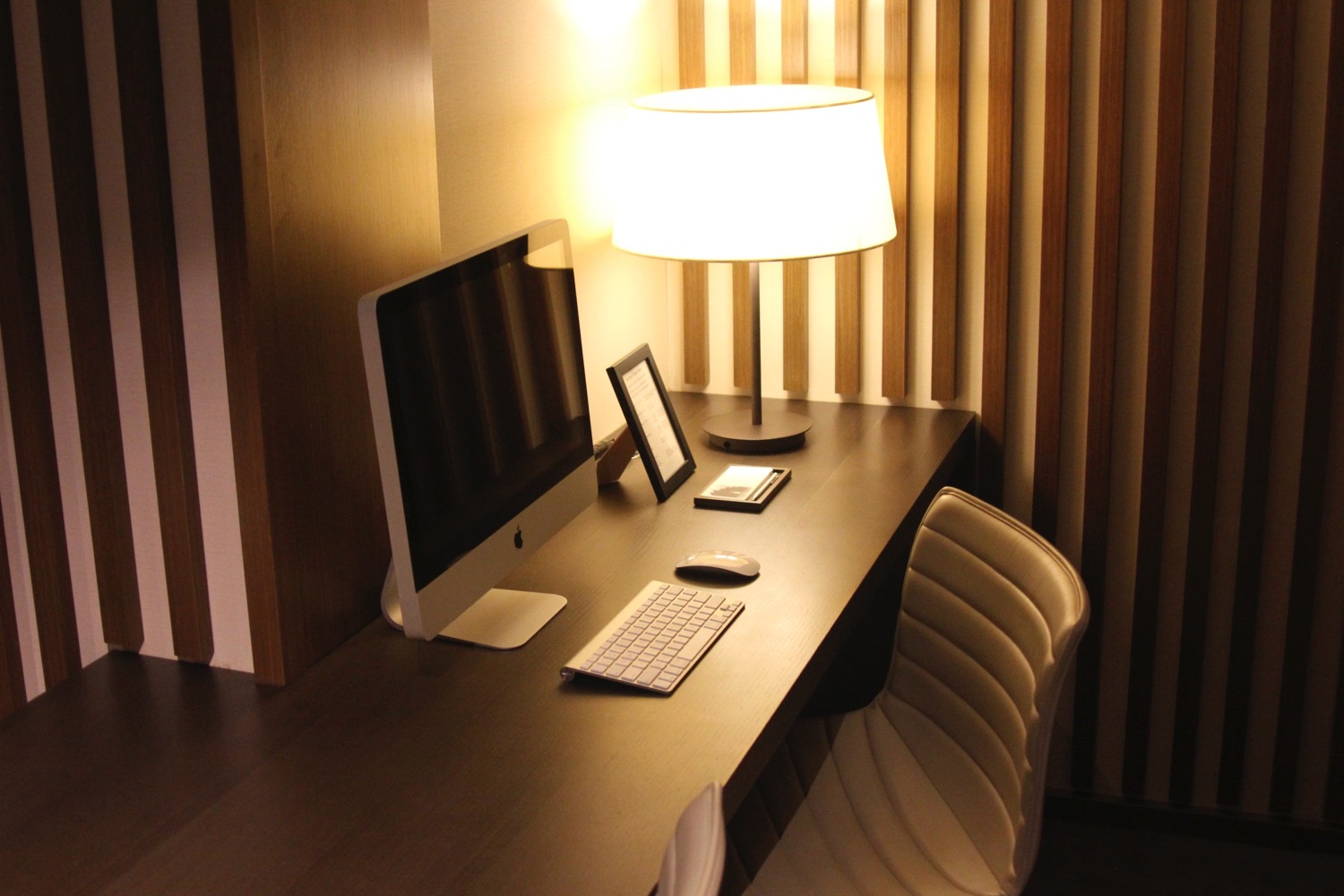 a desk with a computer and a lamp