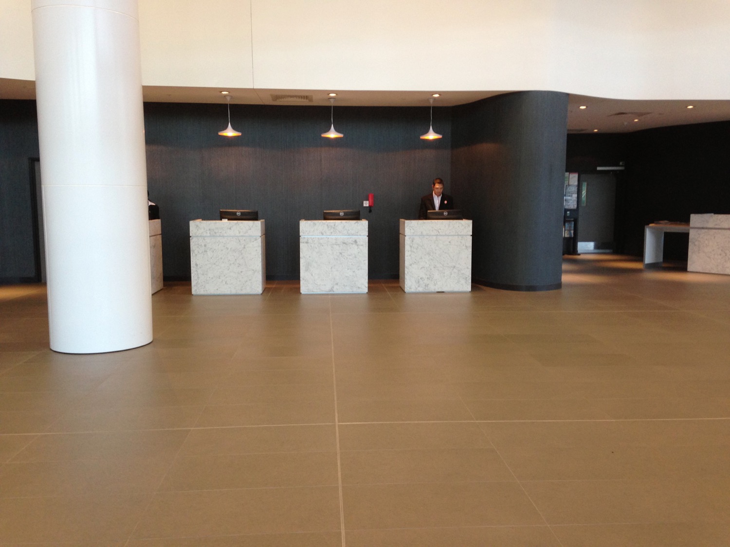 a man standing at a desk in a lobby