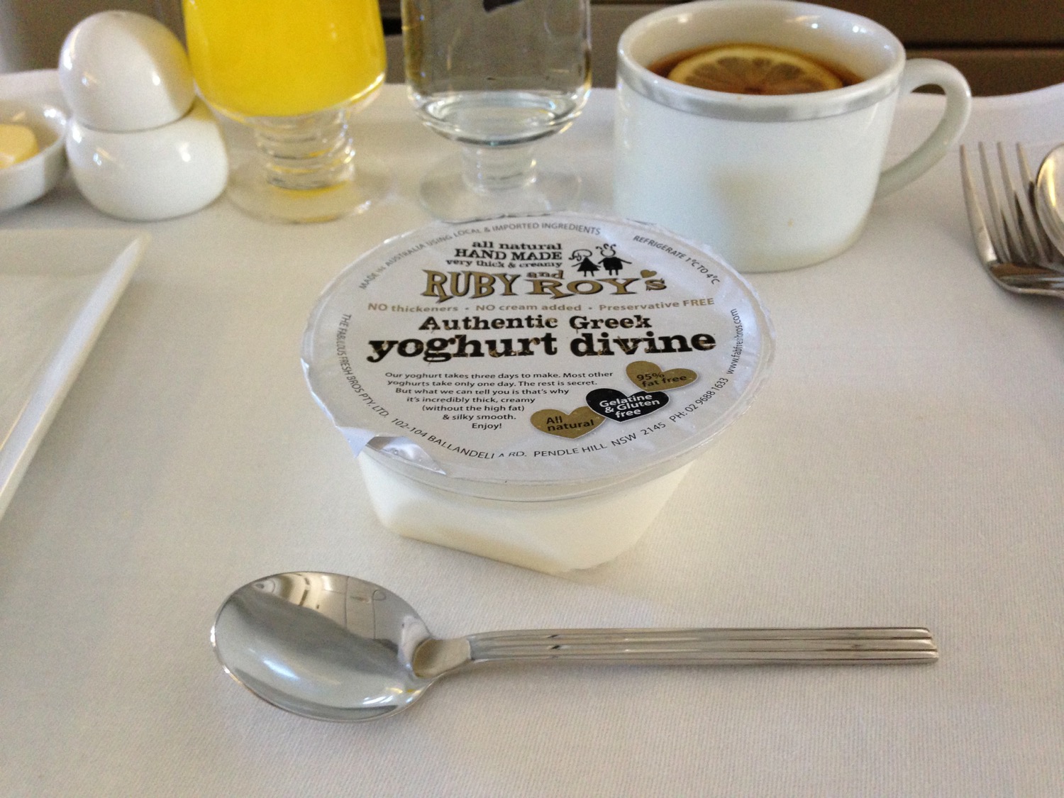 a cup of yogurt and a spoon on a table