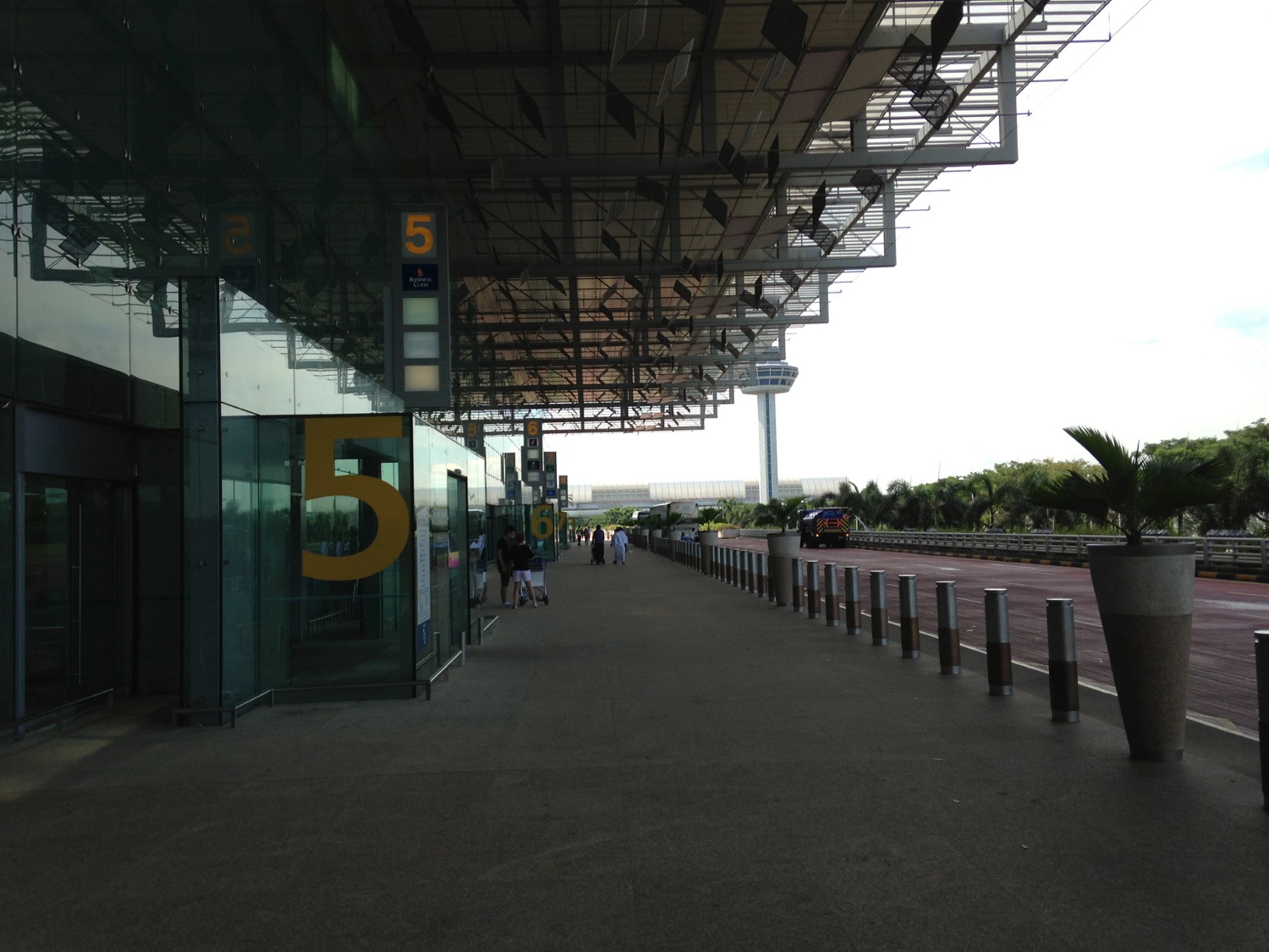 a walkway with glass walls and a building with numbers