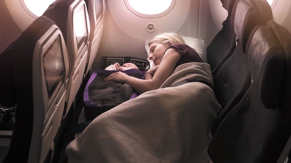 a woman sleeping in an airplane with a baby