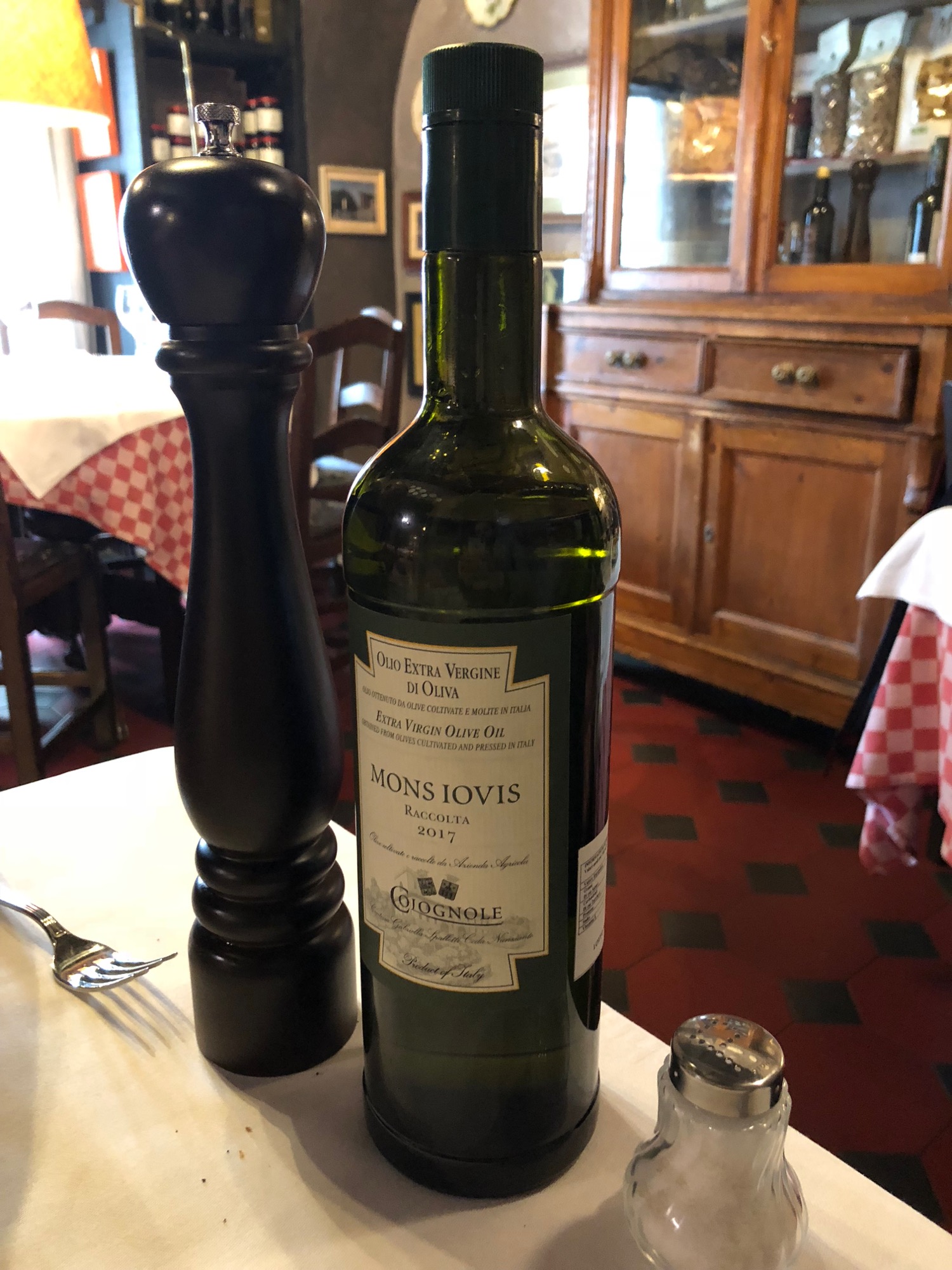 a bottle of wine next to a pepper mill