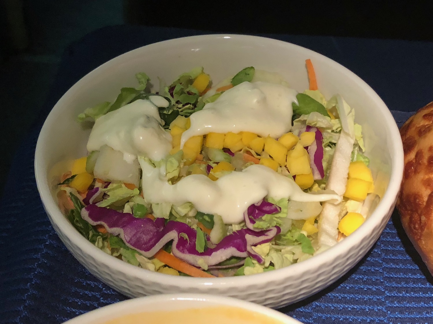 a bowl of salad with white dressing