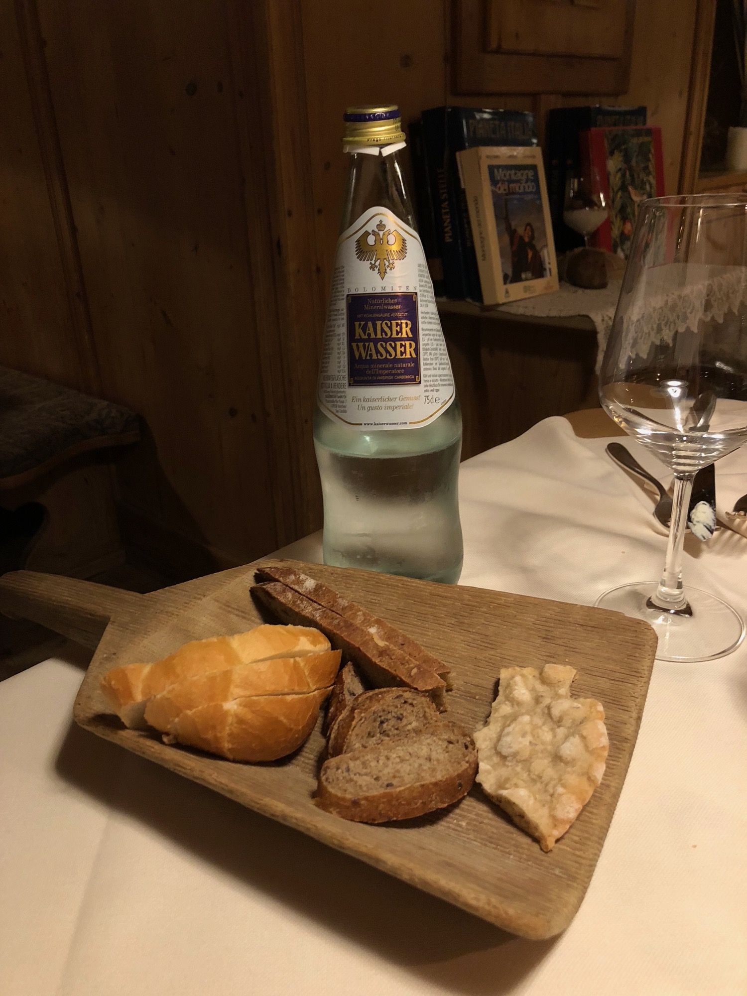 a wooden tray with bread and a bottle of water on a table