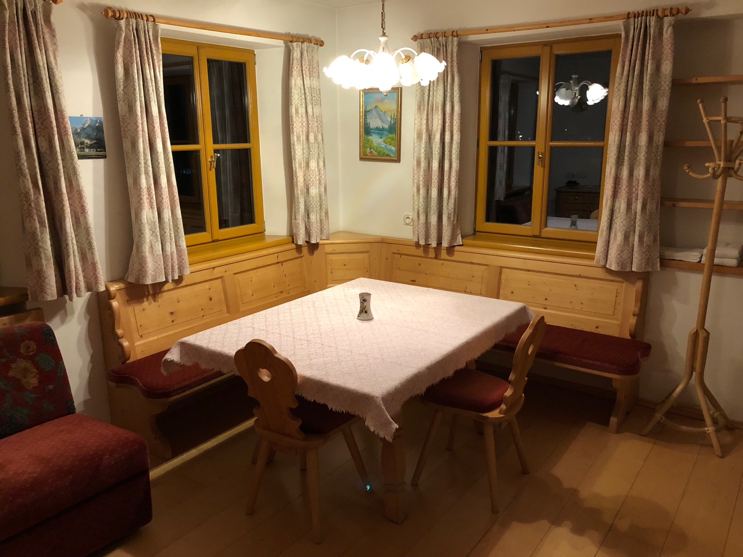 a table with chairs in a room with windows and a chandelier