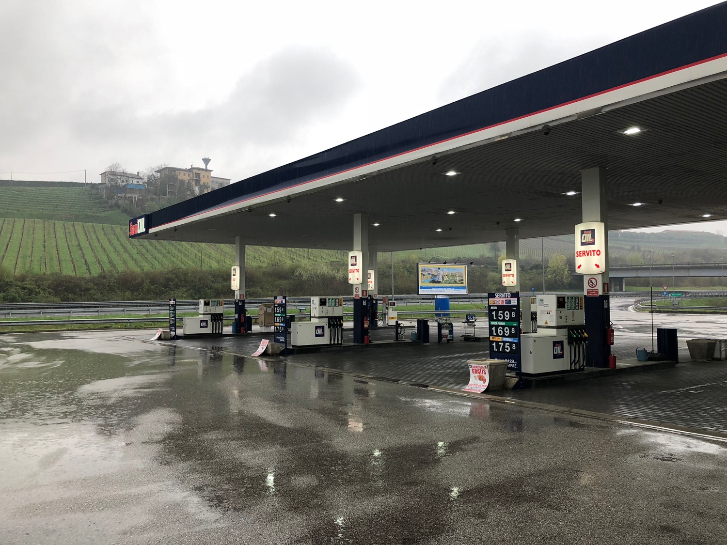 a gas station with a green field in the background