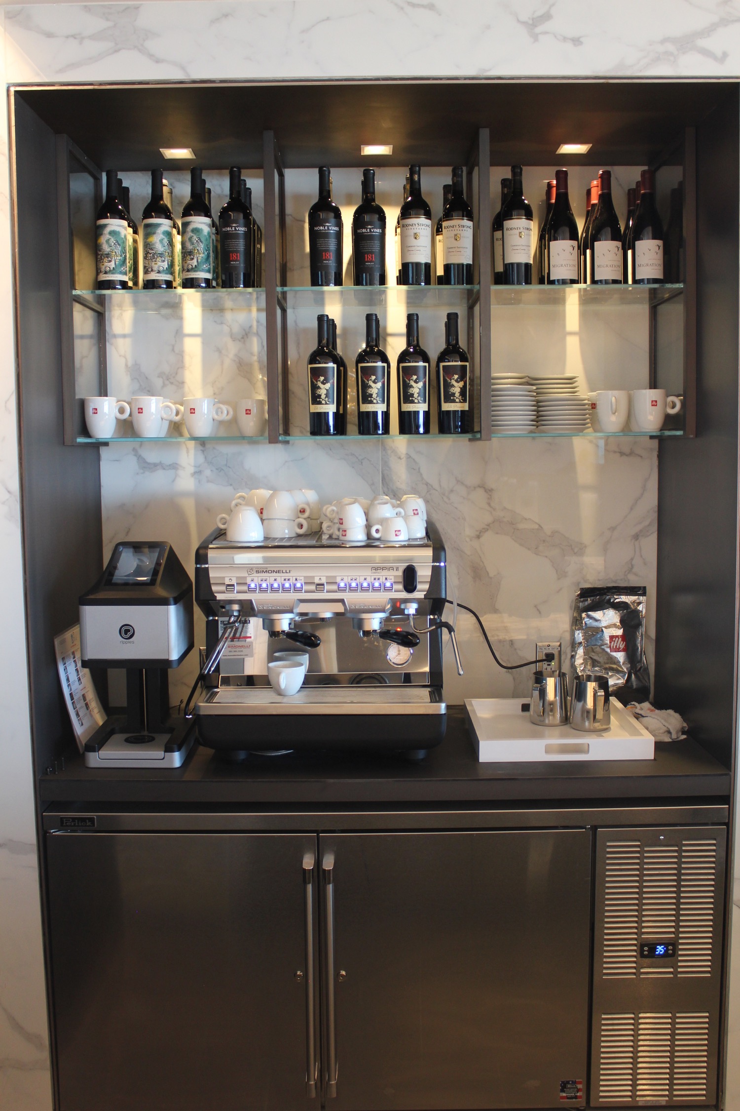 a coffee machine and bottles of wine on a shelf