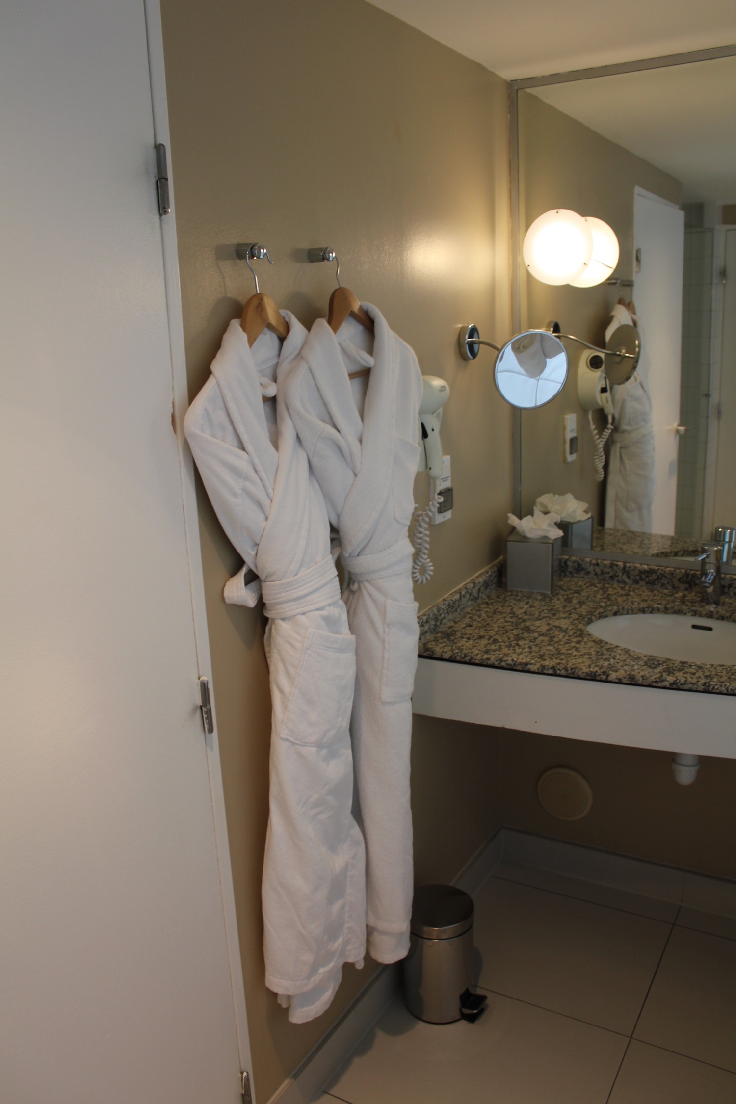a white bathrobes on a hook in a bathroom