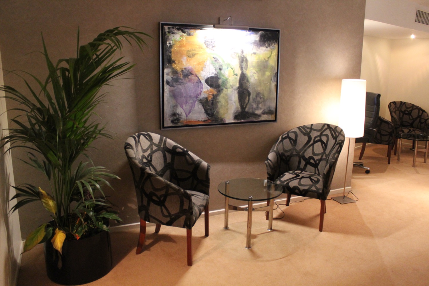 a room with chairs and a painting on the wall