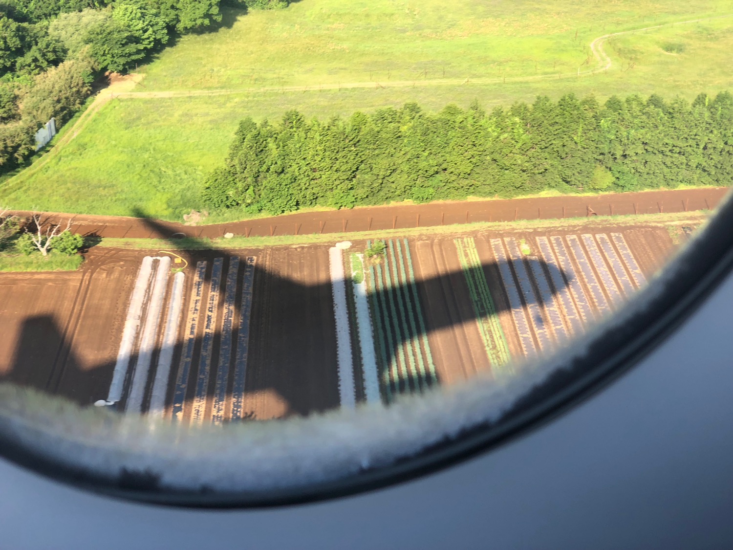 a view of a field from a plane window