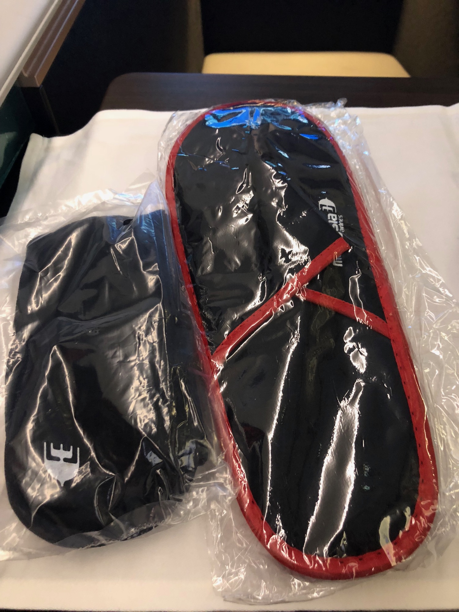 a black and red slippers in a plastic bag
