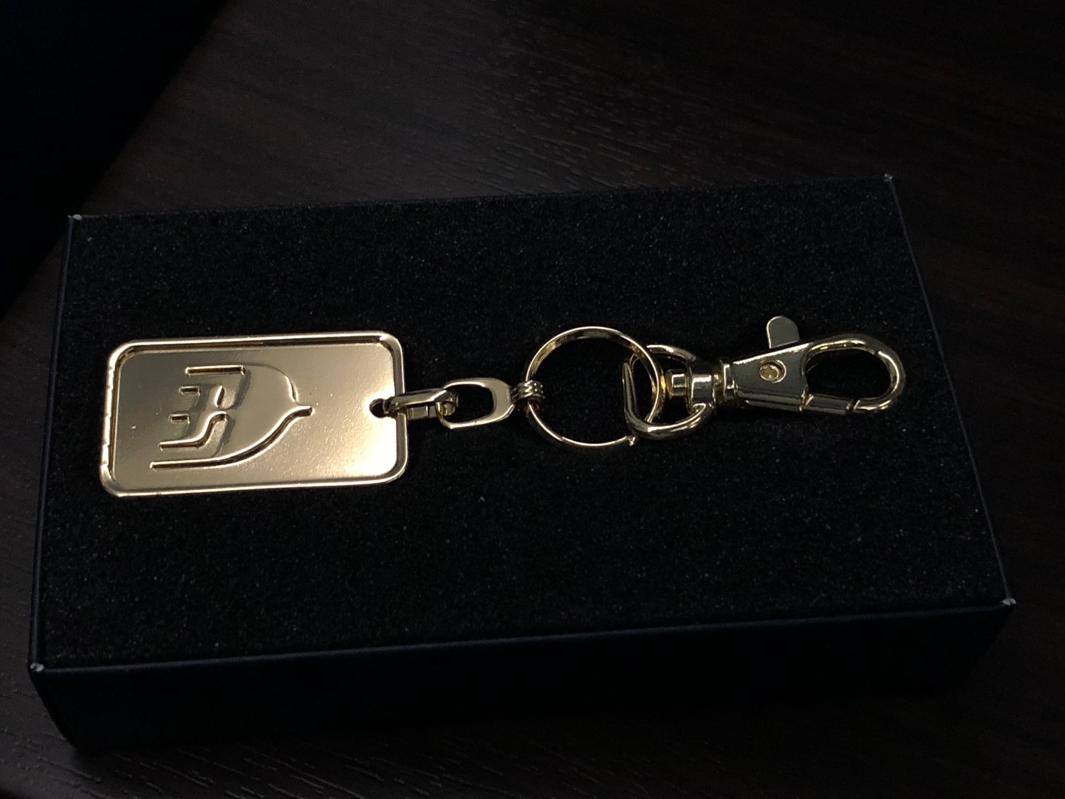 a gold key chain on a black surface