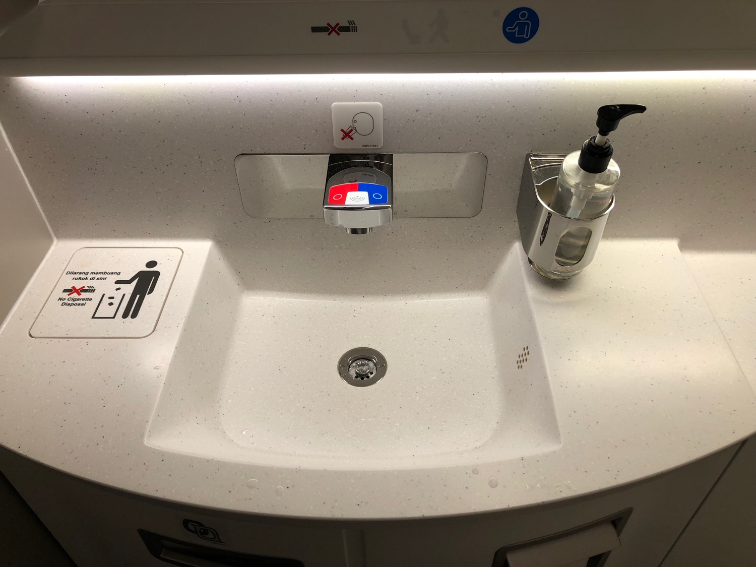 a sink with a soap dispenser and a bottle of liquid