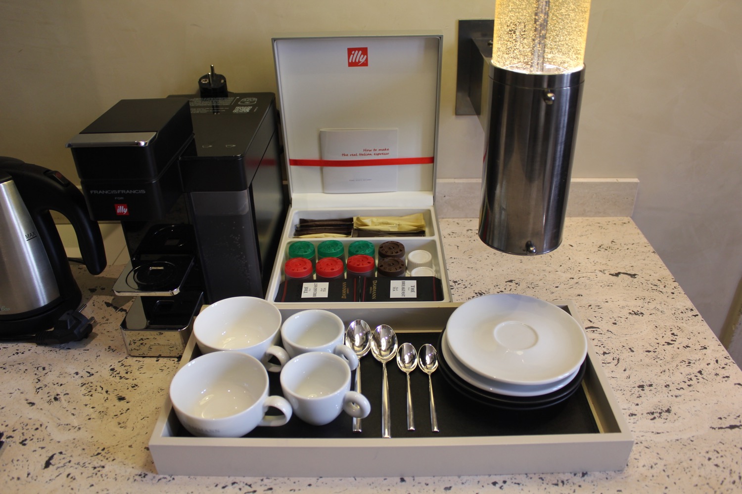 a coffee machine with a tray of white cups and spoons