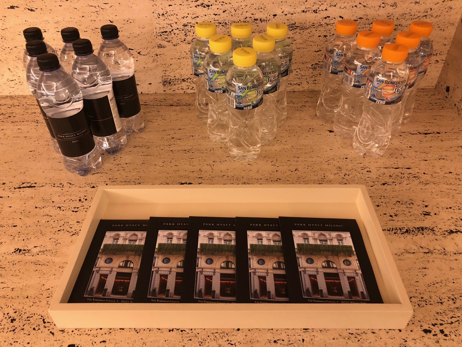 a group of water bottles and a tray of photos