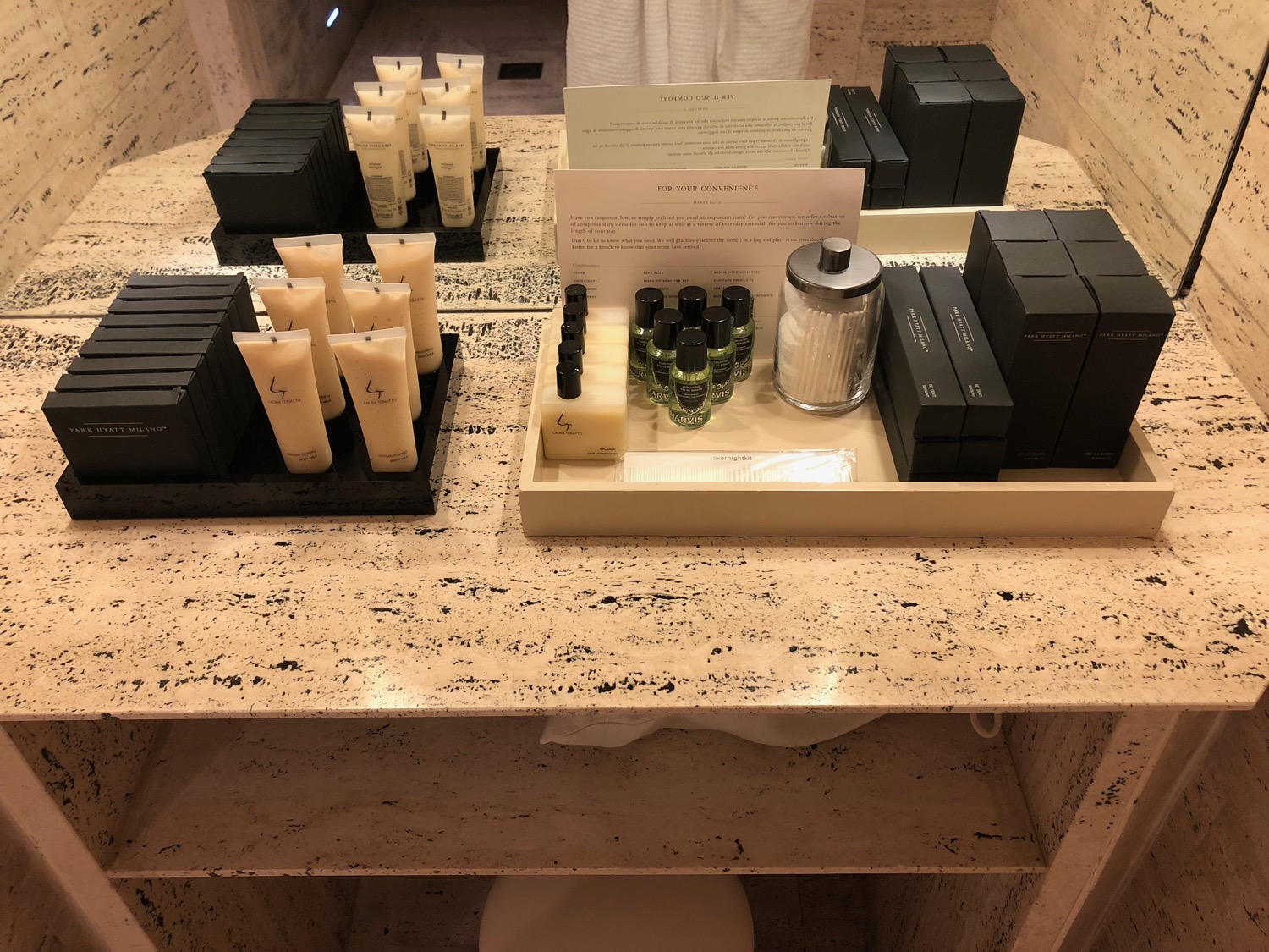 a bathroom counter with a group of toiletries and a sign