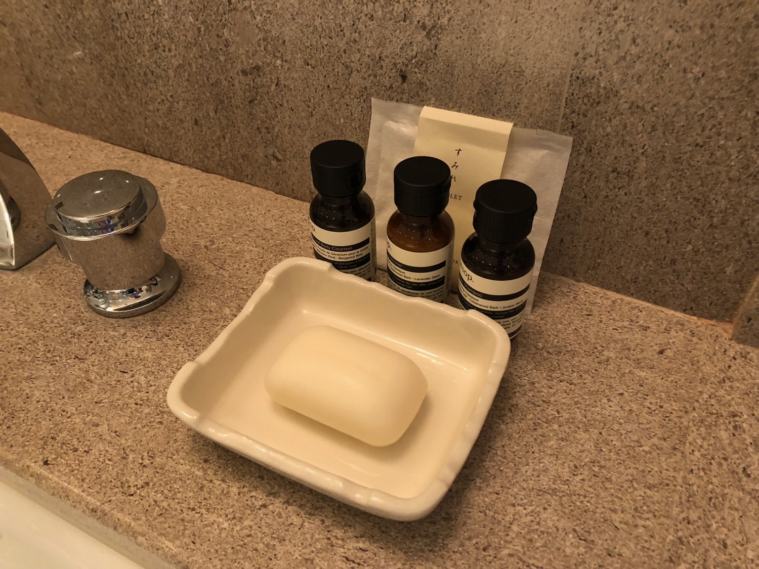 a soap dish and small bottles of liquid on a counter