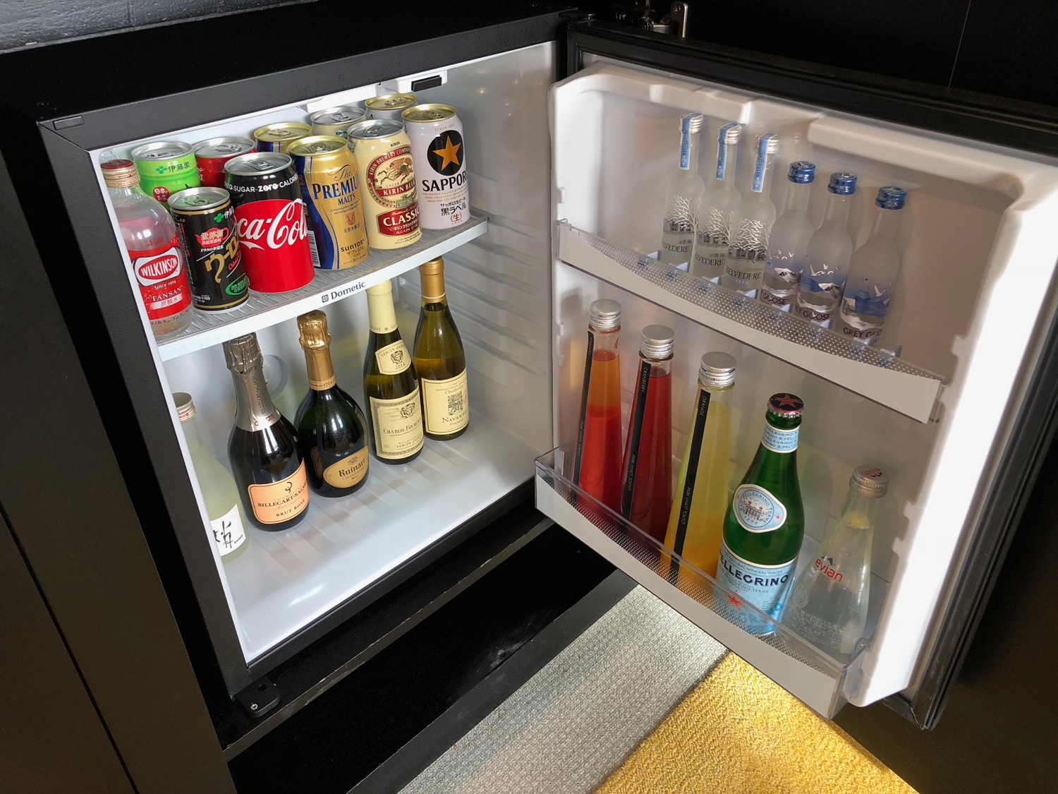 a mini fridge with bottles of alcohol and drinks