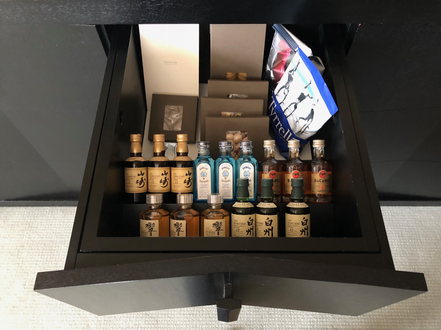 a drawer with small bottles of liquor
