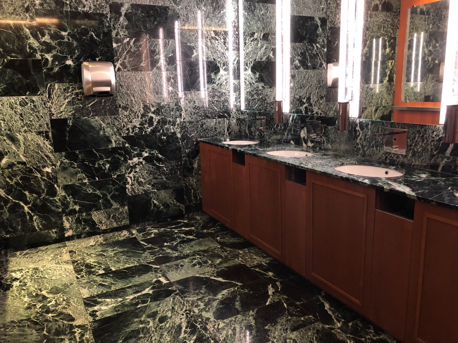 a bathroom with marble tiles and sinks