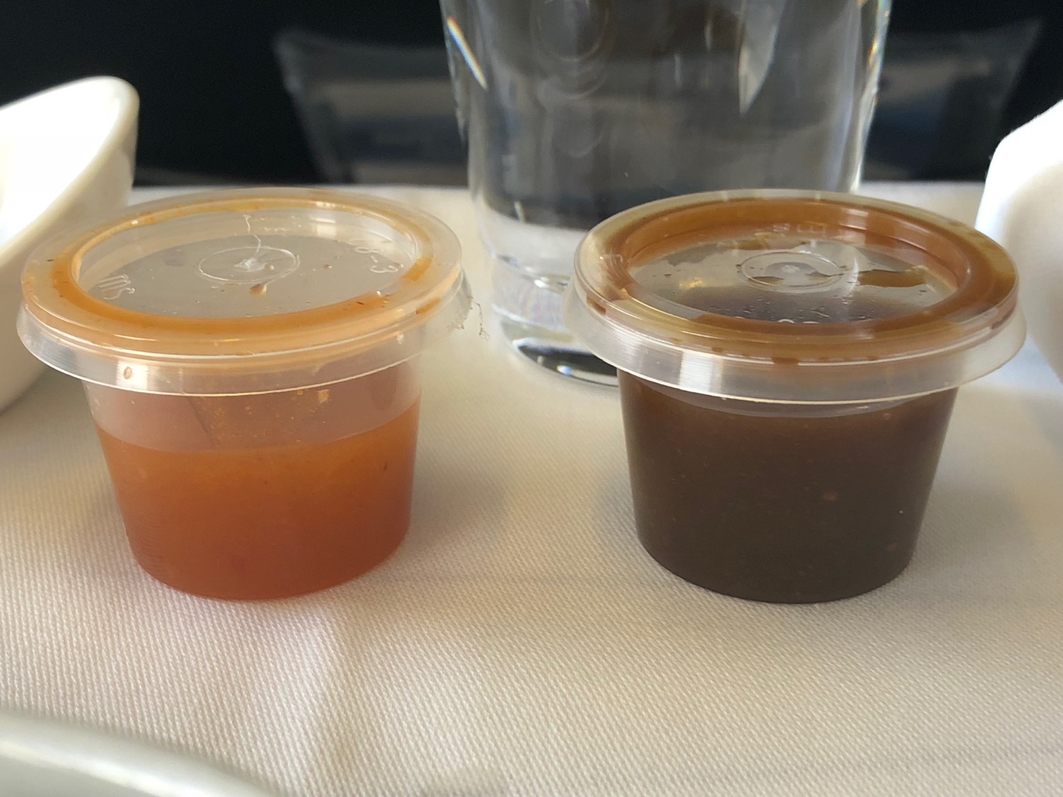 a couple of small plastic containers with brown liquid in them
