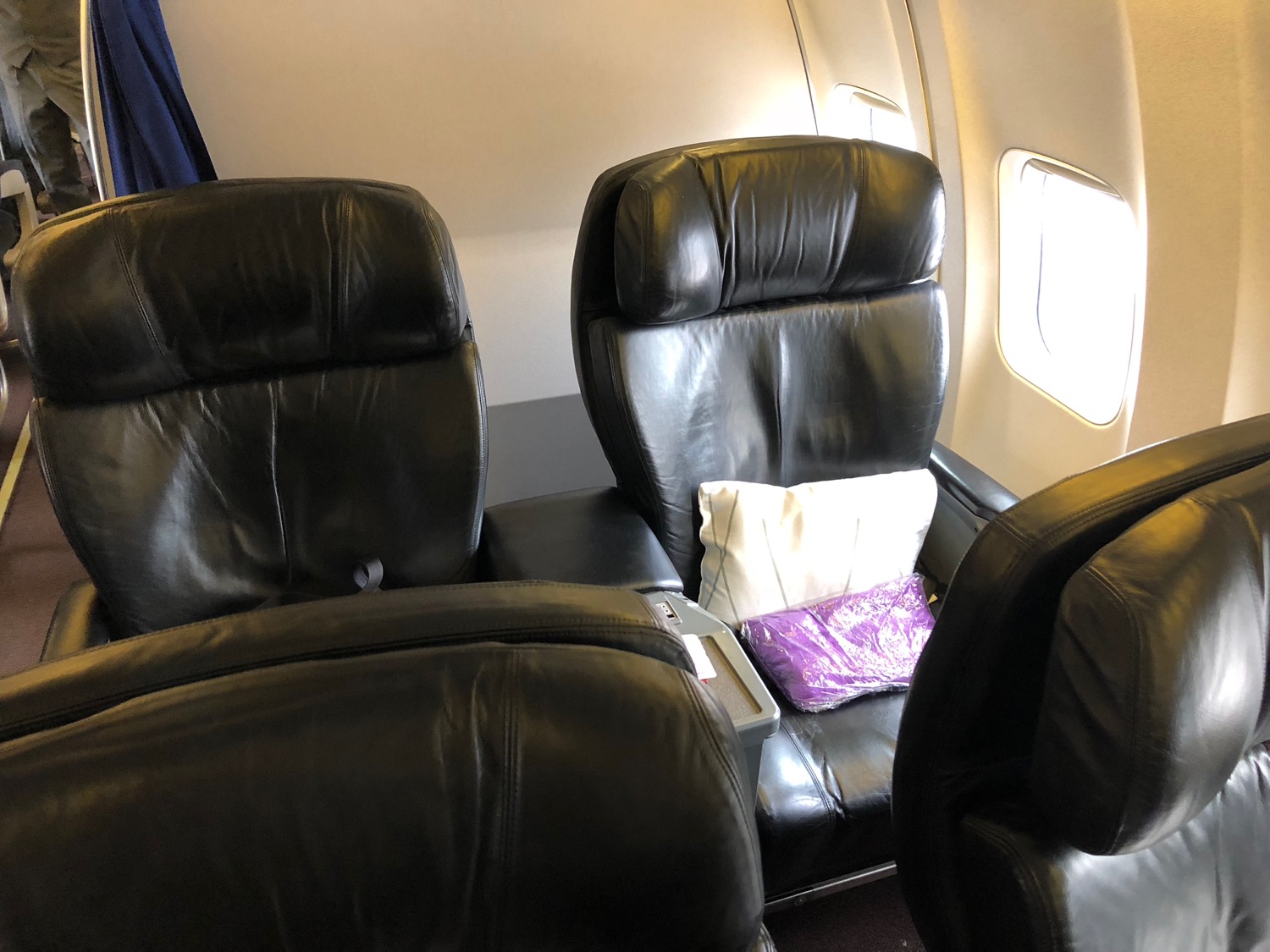 a black leather seats with a pillow on the back