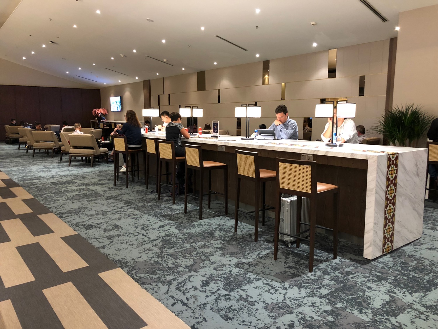 a group of people sitting at a long counter in a hotel