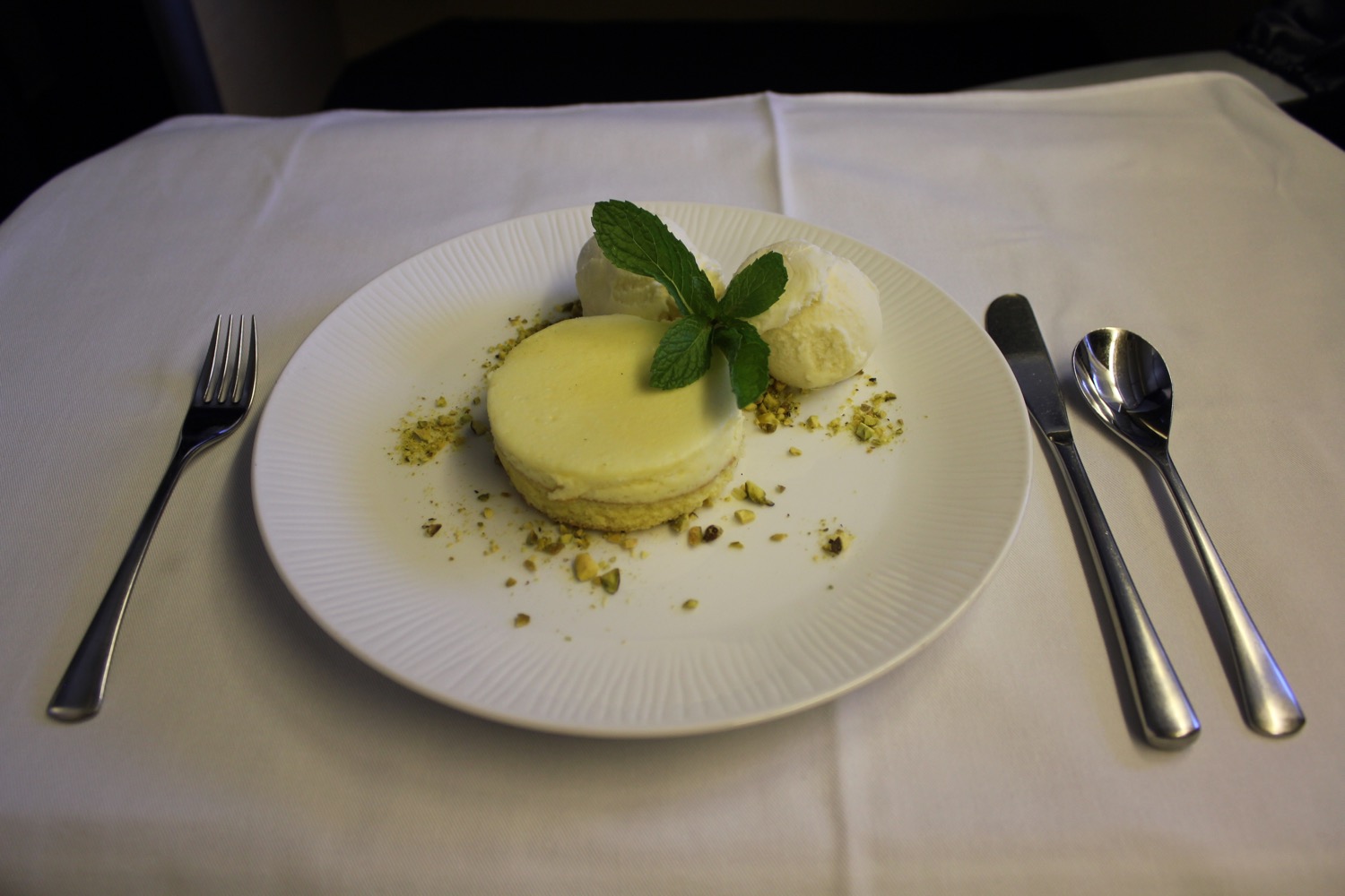 a plate of dessert with ice cream and mint leaves