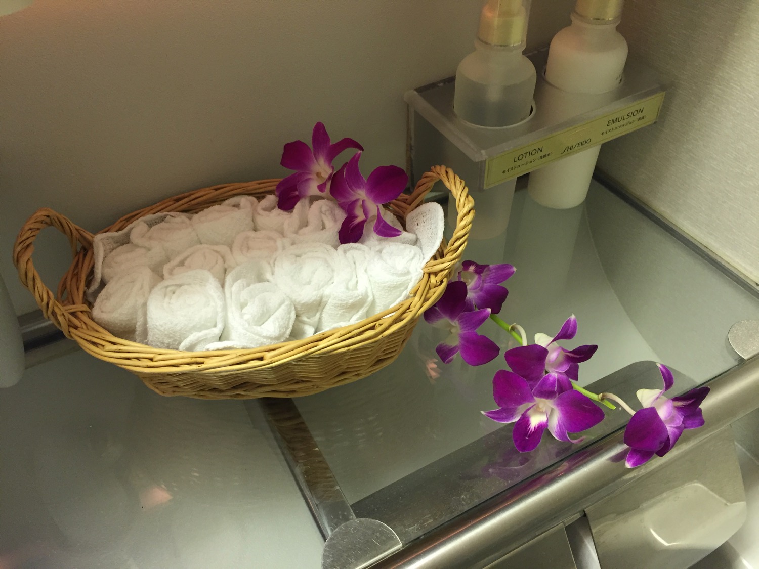 a basket of towels and purple flowers