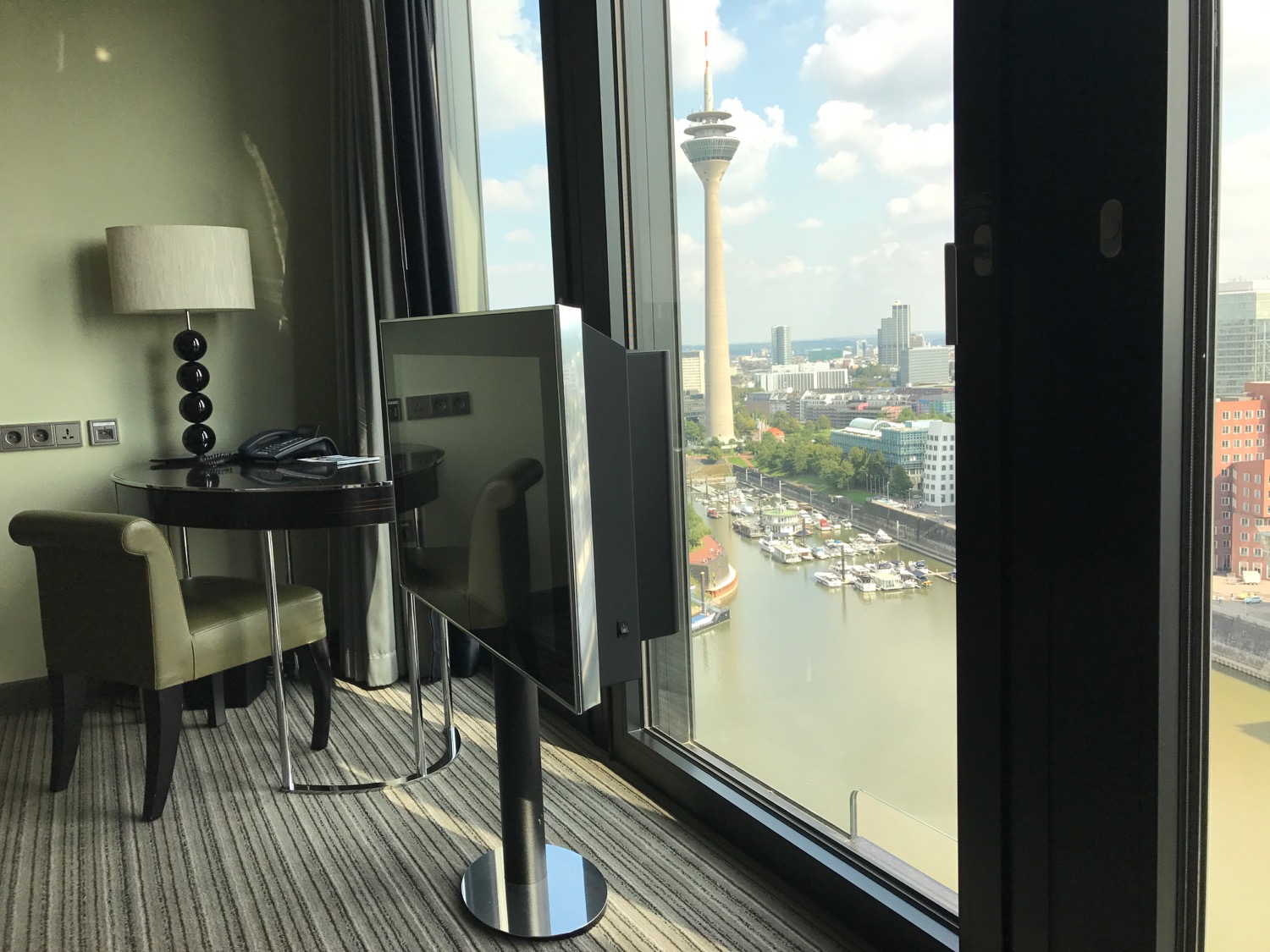 a room with a television and a view of a city and a river